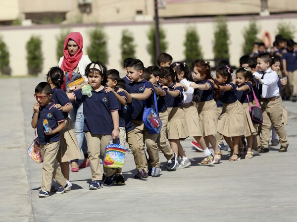 イラク・バグダッドで、新学期に新しい制服を着て教室へ向かう児童ら - Sputnik 日本