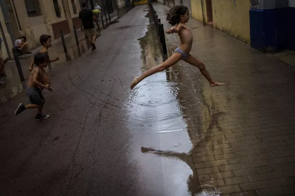 スペイン・バルセロナで水たまりを飛び越える子ども スペイン・バルセロナで水たまりを飛び越える子ども - Sputnik 日本