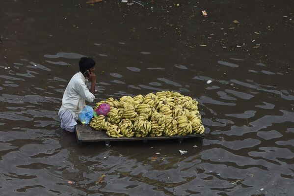 パキスタン・ラホールで、大雨の後冠水した道路をカートでフルーツを運ぶ商人 - Sputnik 日本
