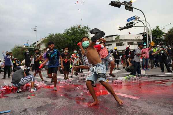 タイ・バンコクで行われた反政府デモで、赤いペンキが入ったボトルを警察に投げつける若者ら - Sputnik 日本