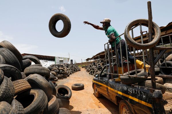 ナイジェリア・イバダンにあるリサイクル工場で、古いタイヤをトラックから降ろす作業員 - Sputnik 日本