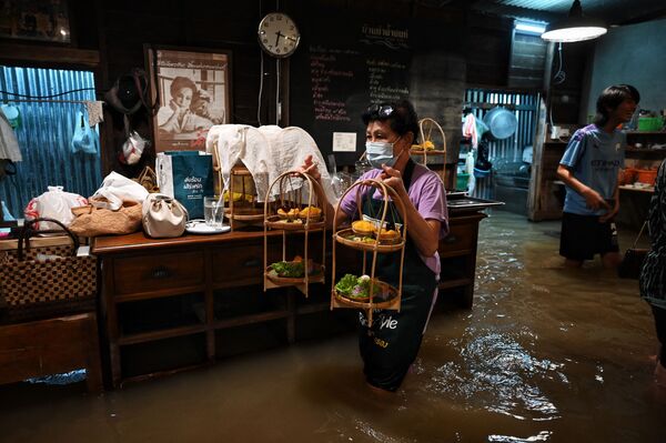 タイ中部・ノンタブリー県で、水浸しになったレストラン「Chaopraya Antique」で働く従業員 - Sputnik 日本