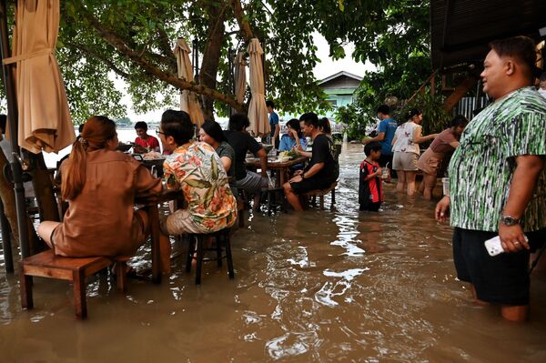 タイ中部・ノンタブリー県で、水浸しになったレストラン「Chaopraya Antique」で食事をする人々 - Sputnik 日本
