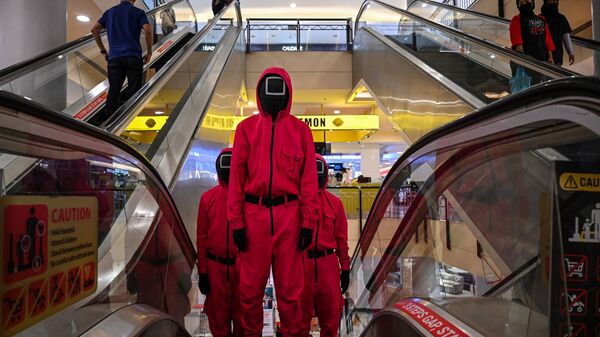 Косплееры в костюмах персонажей из сериала Netflix Игра в кальмара на эскалаторе в торговом центре Куала-Лумпура, Малайзия - Sputnik 日本