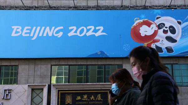 Люди напротив баннера Олимпийских игр в Пекине в Китае  - Sputnik 日本