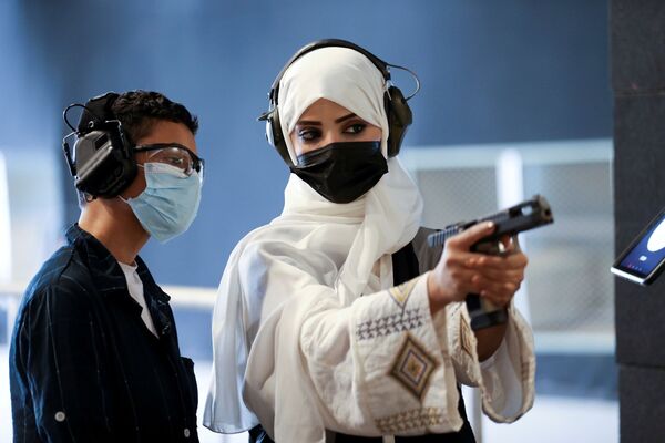 サウジアラビア・リヤドの射撃場で、少年に拳銃の安全な使い方を教えるモナ・アル・フライスさん - Sputnik 日本