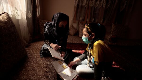 17-летняя Сахар помогает своей 10-летней сестре Хадии с домашним заданием - Sputnik 日本