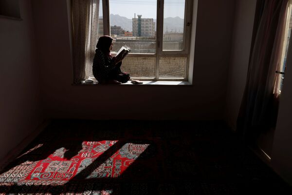 フガニスタンのカブールにある自宅の窓辺で本を読むハワさん - Sputnik 日本