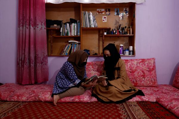 アフガニスタン・カブールにある自宅で一緒に本を読むセウィタさんとサハルさん - Sputnik 日本