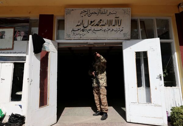 アフガニスタン・カブールにある学校の入り口に立つタリバン戦闘員 - Sputnik 日本