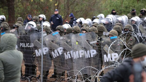 Польские правоохранители и пограничники стоят рядом с забором из колючей проволоки в Гродненской области - Sputnik 日本