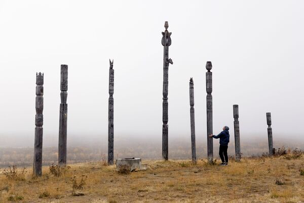 サハ共和国北東部・チェルスキーを流れるコリマ川近くで、シベリア先住民が建てた儀式用の柱を歩く公園職員のヤロスラフ・ヴォローシンさん - Sputnik 日本