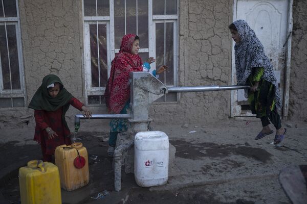 国内避難民キャンプで、タンクに水を注ぐ少女ら（アフガニスタン・カブール、15日） - Sputnik 日本