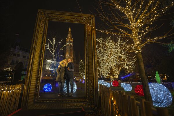 クリスマスマーケットで、市庁舎を背景に写真撮影をする男女（オーストリア・ウィーン、21日） - Sputnik 日本