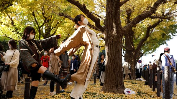 Девушки позируют для юмористических фотографий под осенними листьями в Токио, Япония - Sputnik 日本