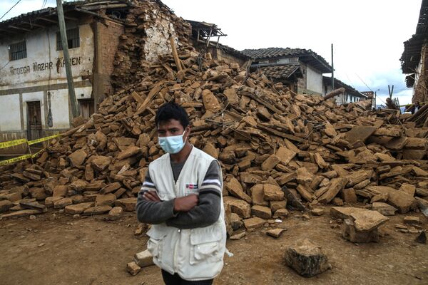 地震で倒壊した建物のそばに立つ男性（ペルー・アマソナス県、28日） - Sputnik 日本