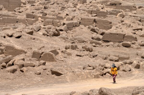 縄で縛られたミイラが発掘されたカハマルキリャ遺跡を歩く女性（ペルー・リマ郊外、30日） - Sputnik 日本