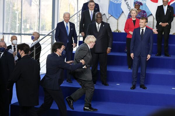 イタリアで10月31日、G20ローマ・サミットが開催（写真：写真撮影に遅刻したボリス・ジョンソン英首相と、手で支えるエマニュエル・マクロン仏大統領） - Sputnik 日本