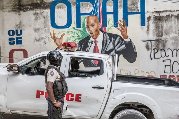 7月7日、ハイチのジョブネル・モイーズ大統領が自宅で武装集団に襲撃され、死亡した（写真：7月15日、モイーズ大統領が描かれた壁の前で警備にあたる警官） - Sputnik 日本