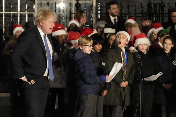ダウニング街で行われたクリスマスツリーの点灯式で、児童合唱団の合唱に耳を傾けるボリス・ジョンソン首相（英国・ロンドン、1日） - Sputnik 日本