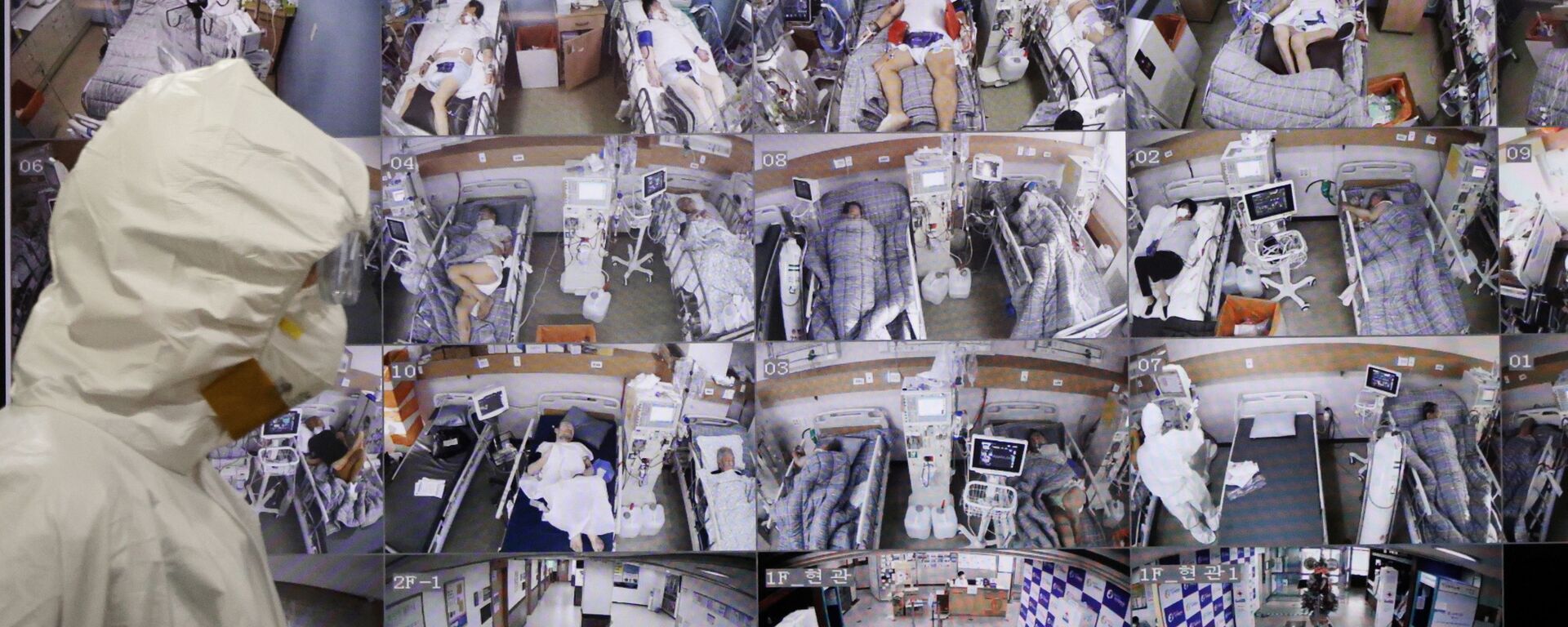 Медицинский работник проходит мимо монитора с видео из палат пациентов в больнице Пхёнтхэке, Южная Корея - Sputnik 日本, 1920, 17.12.2021
