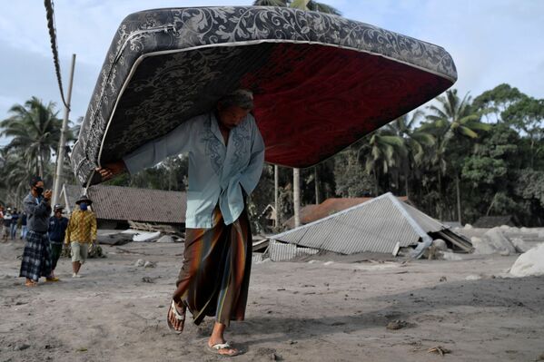噴火の被害にあった地域で、避難のため家具を運ぶ男性（インドネシア・ルマジャン県、5日） - Sputnik 日本