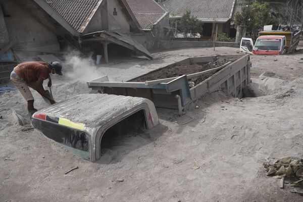 火山灰に埋もれたトラックを掘り起こす男性（インドネシア・ルマジャン県、5日） - Sputnik 日本