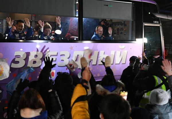 バイコヌール宇宙基地へ向かうバスに乗り込み、関係者らへ手を振る平野陽三氏（左）、前澤友作氏（中）、アレクサンドル・ミシュルキン氏（右） - Sputnik 日本
