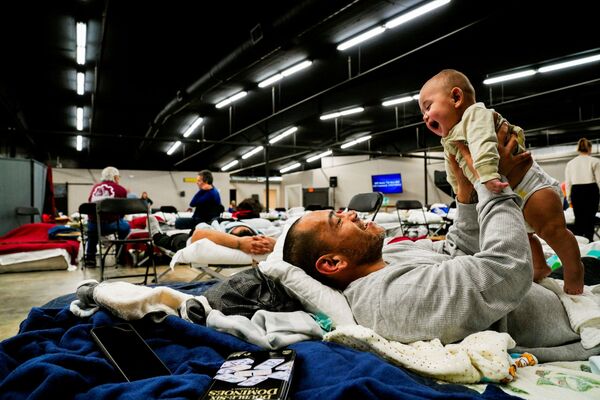 竜巻の被害に見舞われ身を寄せる避難所で、息子をあやす男性（米ケンタッキー州・ウィンゴ、13日） - Sputnik 日本