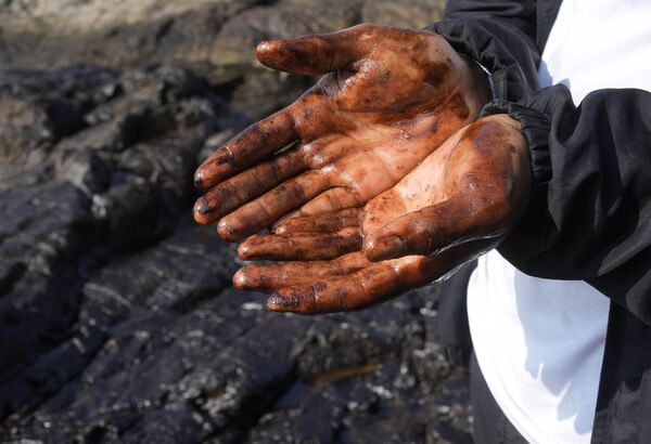 海岸で原油を回収する作業員の手（ペルー・ベンタニージャ、18日） - Sputnik 日本