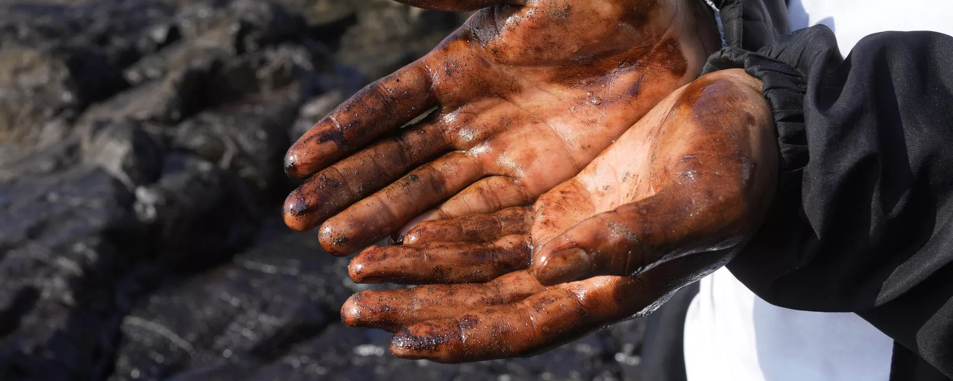 Велосипедист с покрытыми нефтью руками на пляже в Вентанилья, Перу - Sputnik 日本, 1920, 19.01.2022