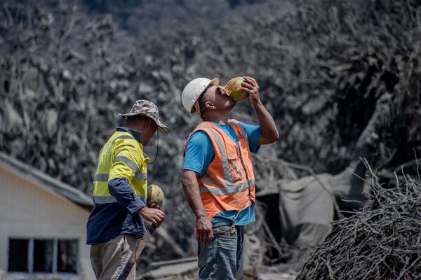 噴火と津波の被害を受けた建物の前に立つ作業員ら（トゥングア島、18日） - Sputnik 日本