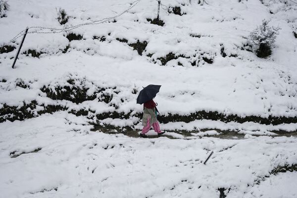 雪が積もった場所を歩く女性（インド・ダラムシャーラー、23日） - Sputnik 日本