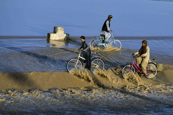 洪水に見舞われた道を自転車で走る少年ら（アフガニスタン・カンダハール、23日） - Sputnik 日本