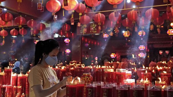 Зажжение свечи в храме во время празднования Нового года по лунному календарю в Индонезии  - Sputnik 日本