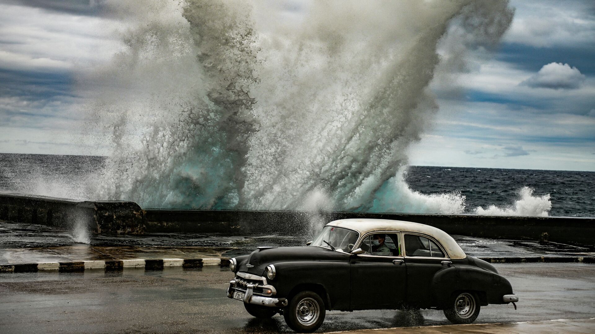 Старый американский автомобиль на фоне гигантских волн в Гаване, Куба - Sputnik 日本, 1920, 05.03.2022