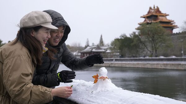 Китайская пара лепит снеговика возле Запретного города в Пекине - Sputnik 日本