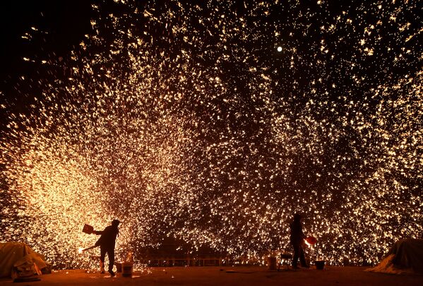 元宵節の前夜祭で、溶けた金属を投げて火花を散らす鍛冶屋（中国・北京、15日） - Sputnik 日本