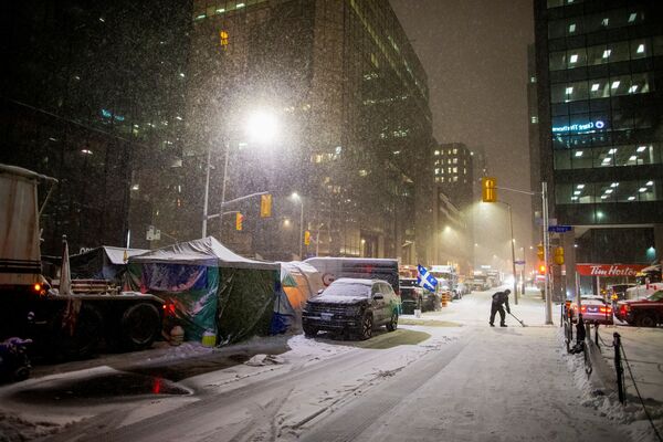 ワクチン義務化に対する抗議デモが続く中、通りで雪かきをする男性（カナダ・オタワ、15日） - Sputnik 日本