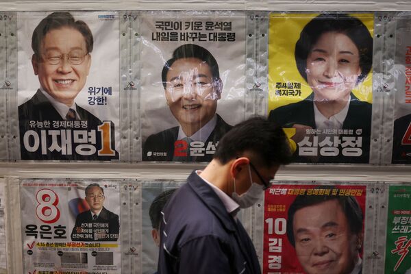 大統領選の立候補者のポスターの前を通り過ぎる男性（韓国・ソウル、4日） - Sputnik 日本