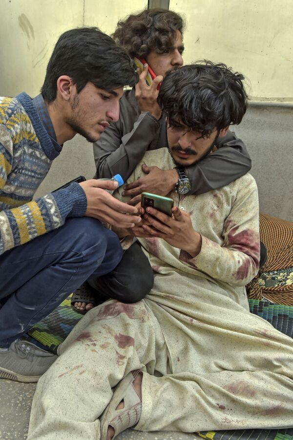 病院の外でスマートフォンを見る負傷者（パキスタン・ペシャーワル、4日） - Sputnik 日本