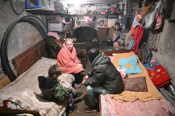 ウクライナ軍の砲撃で、家の地下シェルターに身を隠す親子（ドネツク人民共和国・ゴルロフカ、8日） - Sputnik 日本