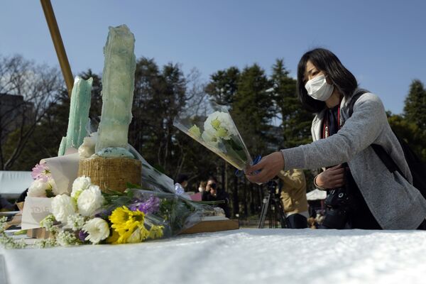 追悼集会で、献花台に花を手向ける女性（東京都、11日） - Sputnik 日本