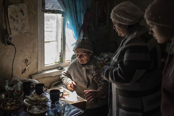 娘のタチヤナさん、孫のアリーナさんと一緒に自宅のキッチンに入るヴェラ・ポルコヴニコワさん（ルガンスク人民共和国・ボロテンノエ、19日） - Sputnik 日本