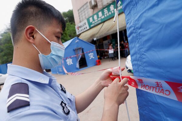 墜落現場付近の村で規制テープを張る警官（中国・広西チワン族自治区梧州市近郊、21日） - Sputnik 日本