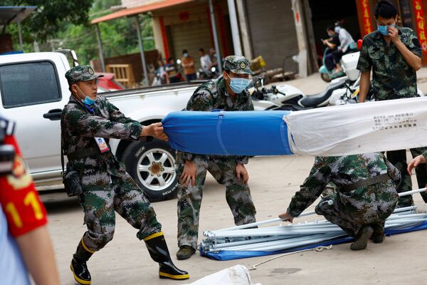 墜落現場付近の村でテントを張る準備をする民兵（中国・広西チワン族自治区梧州市近郊、21日） - Sputnik 日本
