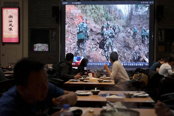 中国東方航空ボーイング737型機墜落のニュースを見ながら食事をする人々（中国・北京、22日） - Sputnik 日本