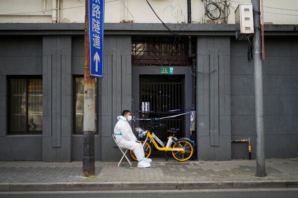 封鎖された建物の入り口の外で見張りをする防護服姿の作業員（上海、29日） - Sputnik 日本