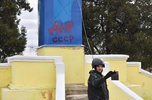 「DNR USSR」と刻まれた記念碑を背に撮影するジャーナリスト（ドネツク人民共和国・グラニトノエ、3月6日） - Sputnik 日本