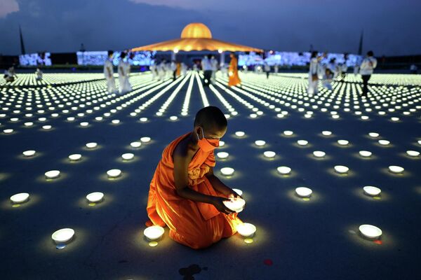 仏教寺院「ワット プラタンマカーイ」で、アースデーを記念してLED電球を並べる若い僧侶（タイ・パトゥムターニー県、22日） - Sputnik 日本